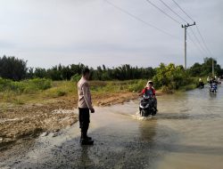 Jalan Terendam Air, Bhabinkamtibmas Polsek Cenrana Bantu Mengarahkan Kendaraan Warga