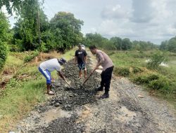 Bhabinkamtibmas Bersama Warga Gotong Royong Perbaiki Jalan Rusak di Desa Binaannya